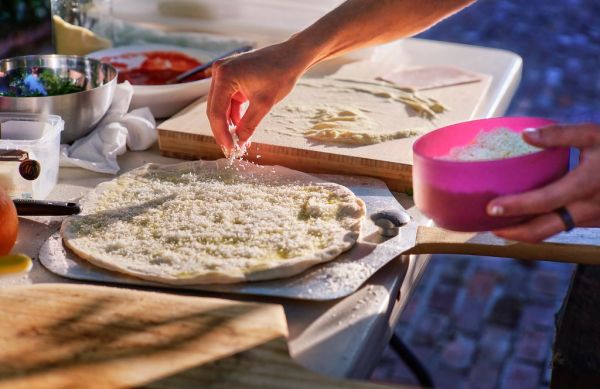 Preparing a Doppio Zero pizza in the backyard for our guests