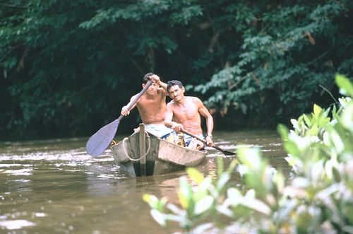 Men make their way down a tributary of the Amazon river