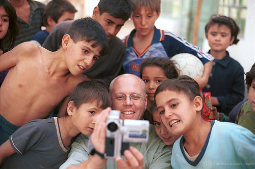 Photographer takes and shows digital video images of himself and young children. Tajikistan