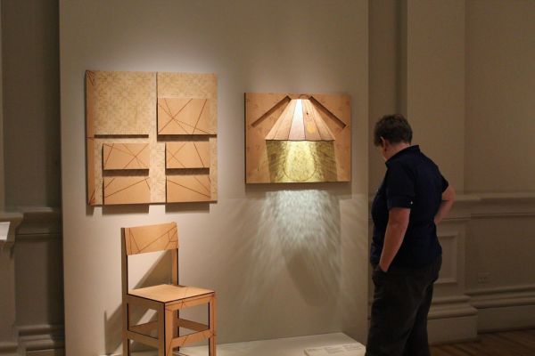 Visitor admires 'Crane Chair' and 'Mosquito Lamp' by Christy Oates