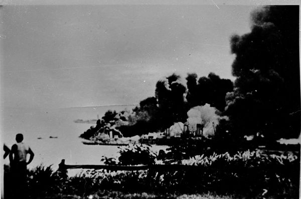 Feb 19, 1942: HMAS KARA KARA's funnel stands up amid the destruction at Darwin's Stokes Hill Wharf - NTL.