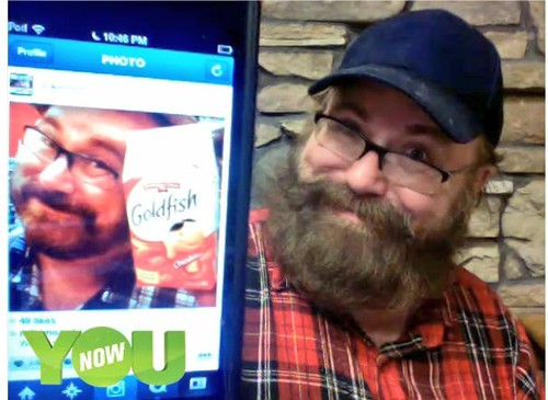 Mike Mozart shows a comparison of two month beard growth from stubble using a picture on his iPhone during a live YouNow Broadcast