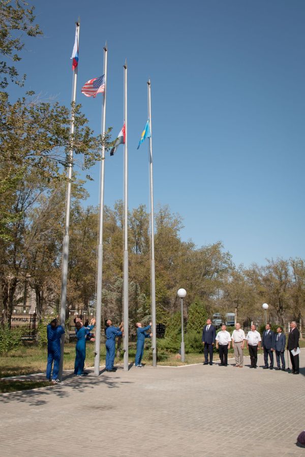 The prime and backup crewmembers for the next launch to the space station raise the flags of Russia, the United States, the United Arab Emirates and Kazakhstan