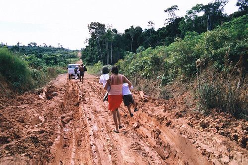 Walking on a mud-filled road in the Amazon